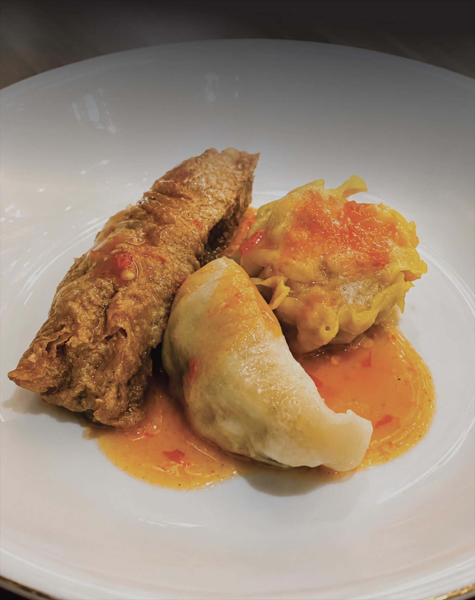 Dimsum goreng dan kukus dengan saus merah di piring putih