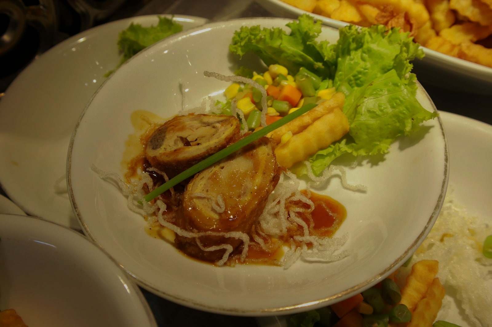 Hidangan piringan dengan saus cokelat, kentang goreng, dan sayuran