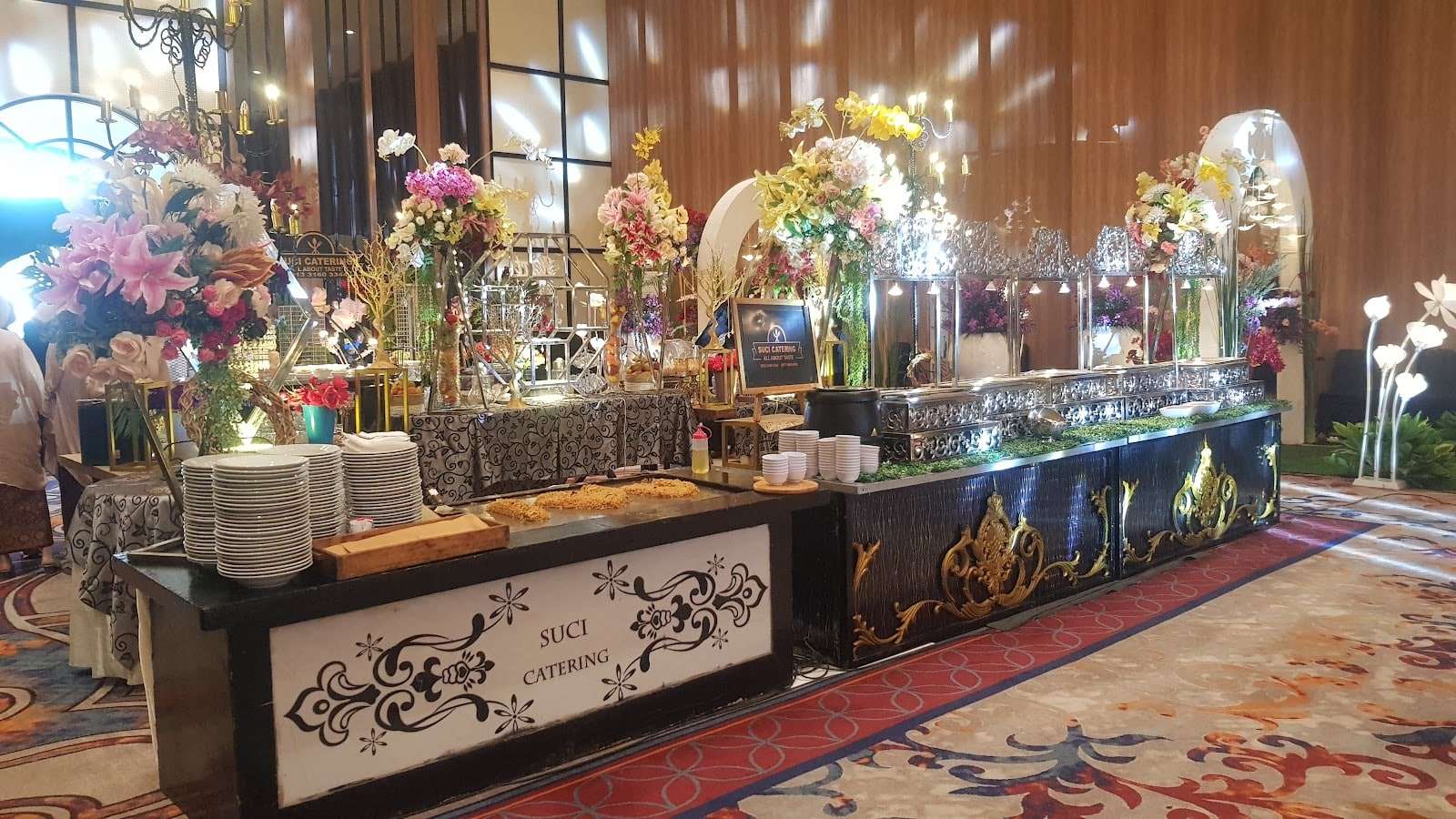 Meja prasmanan Suci Catering dengan rangkaian bunga di sebuah gedung pernikahan