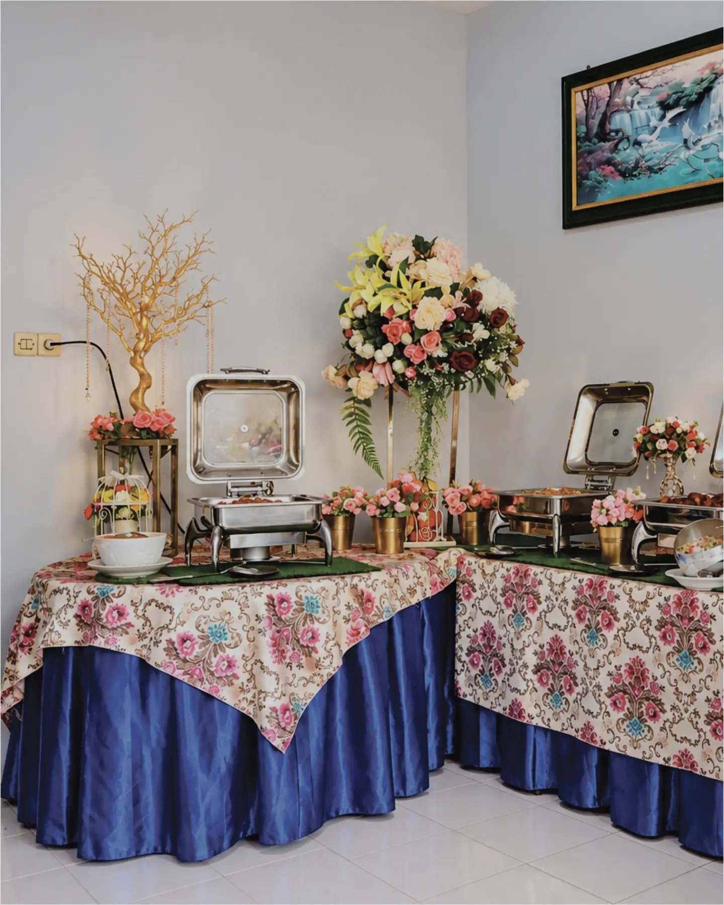 Meja prasmanan Suci Catering dengan taplak bunga dan rangkaian bunga di acara rumahan