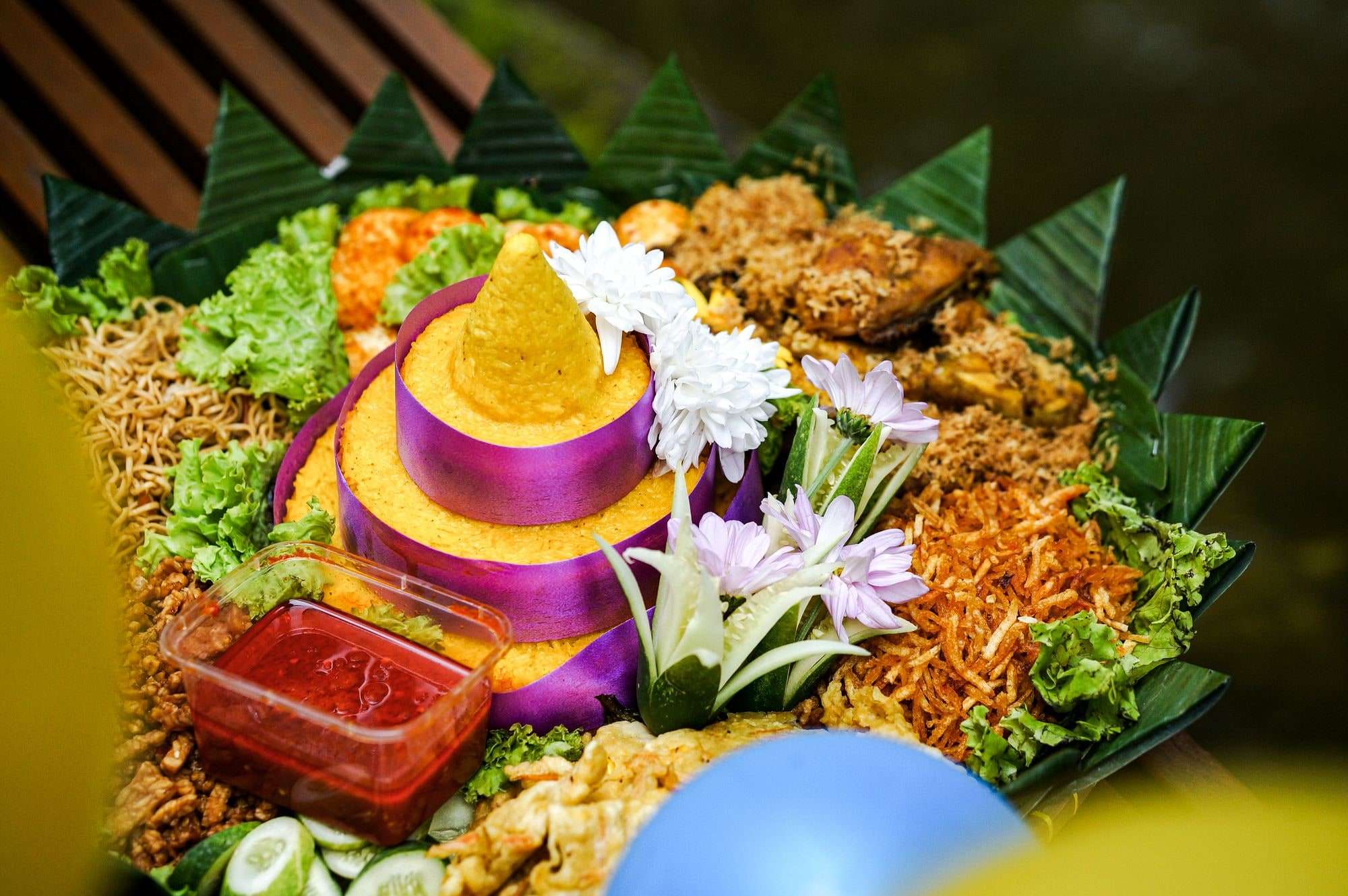 Tumpeng nasi kuning dengan lauk dan hiasan daun pisang (foto ilustrasi)